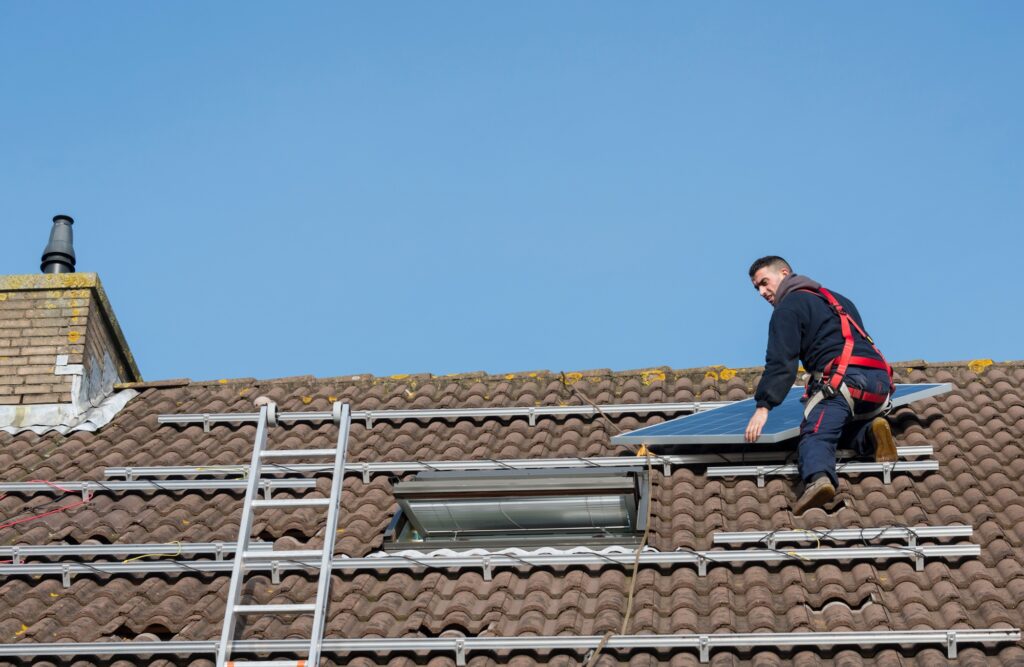 man putting the solar panel on the roof